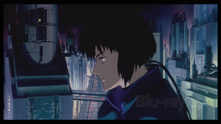 Film frame: Kusanagi in profile above the neon city skyline