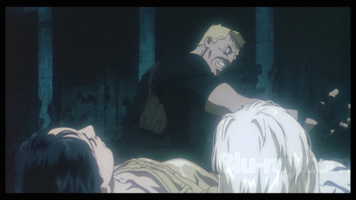 Film frame: a hacked man lunging in a dark interrogation room